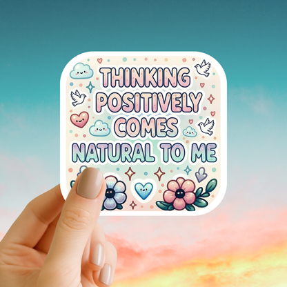 Sticker with 'Thinking positively comes natural to me' text held by a hand against a colorful background